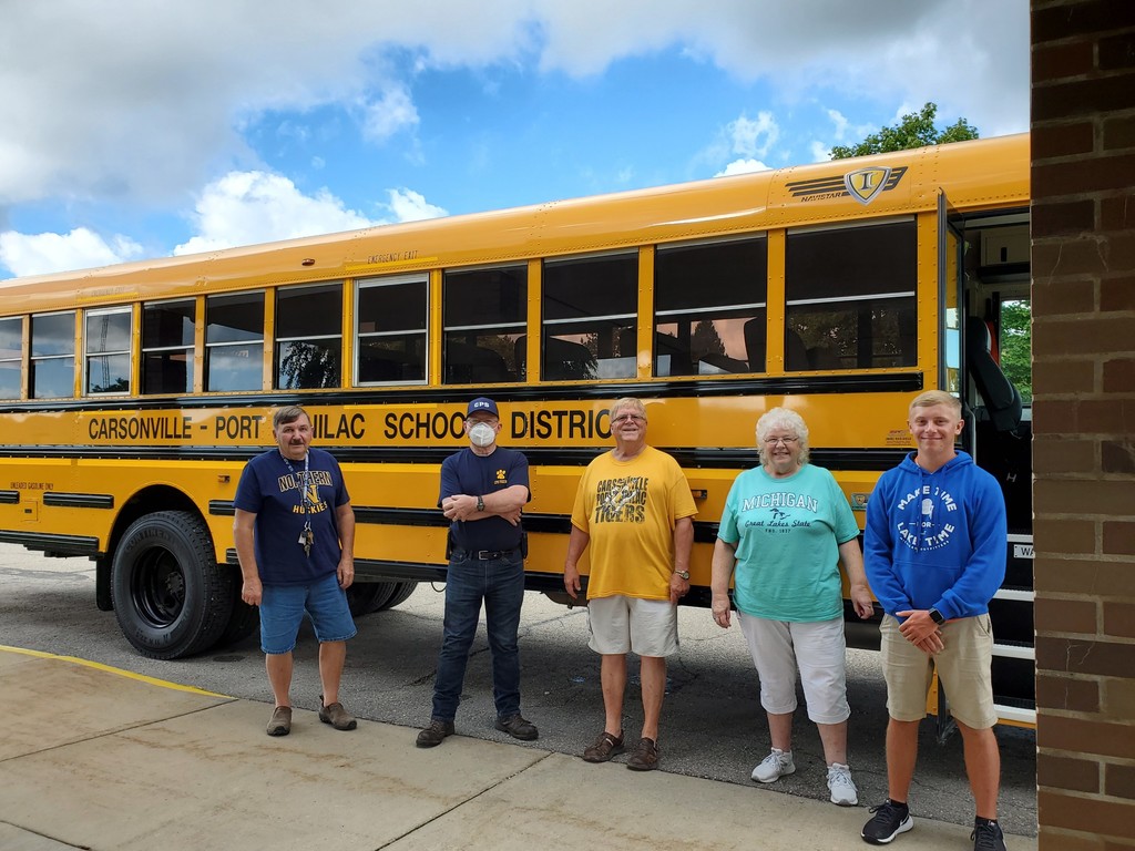 CPS bus drivers pose in front of a bus